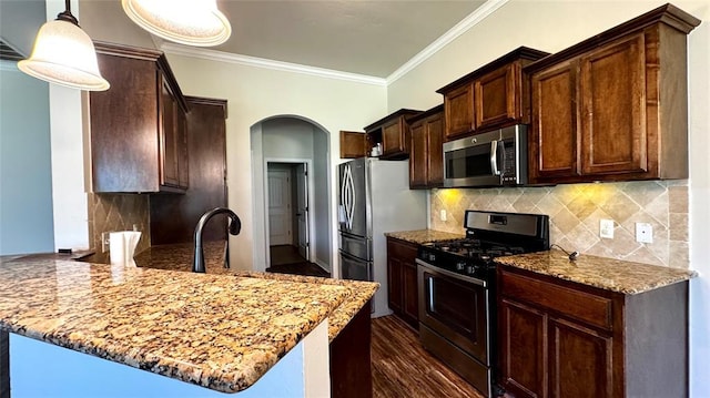 1328 Ridgeway Dr, Moore, OK 73160 - kitchen featuring appliances with stainless steel finishes, arched walkways, a peninsula, light stone counters, and crown molding