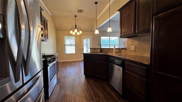 1328 Ridgeway Dr, Moore, OK 73160 - kitchen with appliances with stainless steel finishes, dark wood-style flooring, dark brown cabinets, decorative backsplash, and a peninsula