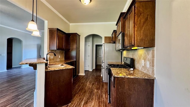 1328 Ridgeway Dr, Moore, OK 73160 - kitchen with arched walkways, a peninsula, ornamental molding, light stone counters, and dark wood-style floors