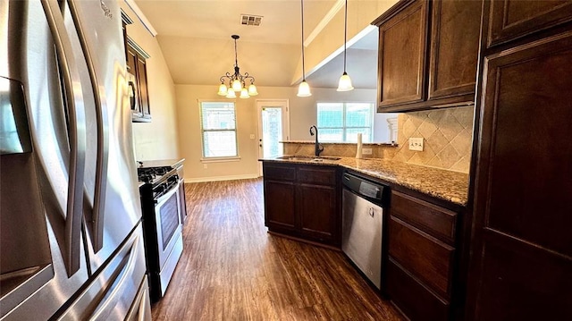 1328 Ridgeway Dr, Moore, OK 73160 - kitchen featuring stainless steel appliances, dark wood-type flooring, backsplash, a peninsula, and a chandelier
