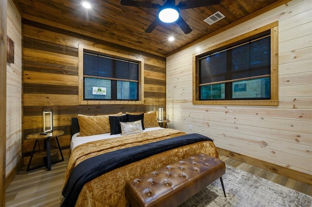 bedroom with wood walls, wood ceiling, wood finished floors, and recessed lighting