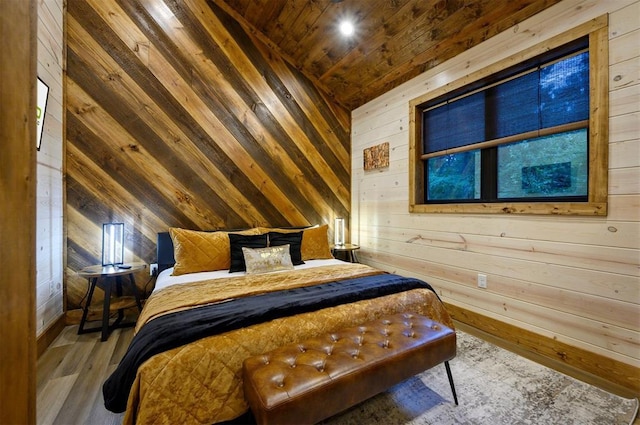 bedroom with wooden walls, lofted ceiling, wood ceiling, wood finished floors, and baseboards