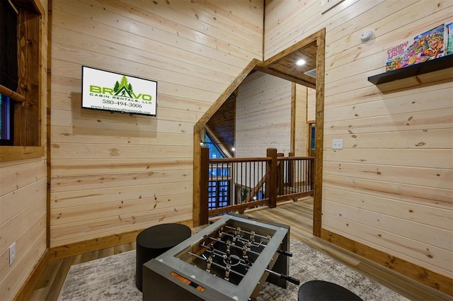 bonus room featuring wood walls and wood finished floors