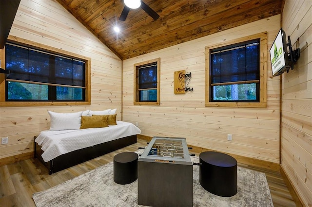 bedroom with lofted ceiling, wooden walls, wooden ceiling, wood finished floors, and a ceiling fan