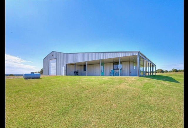 back of property featuring a lawn, an outbuilding, and a garage