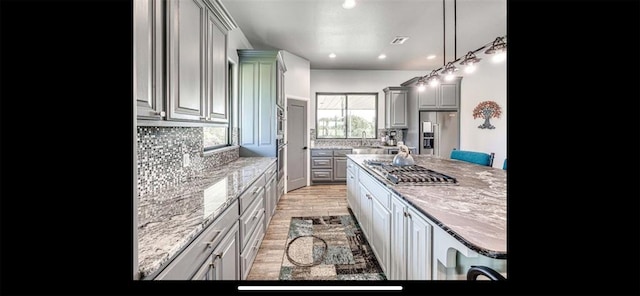 kitchen with gray cabinetry, appliances with stainless steel finishes, decorative backsplash, and recessed lighting