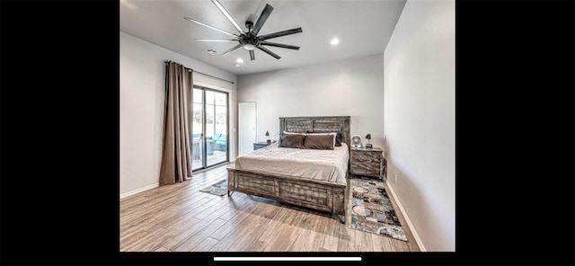 bedroom with recessed lighting, wood finished floors, baseboards, and access to exterior