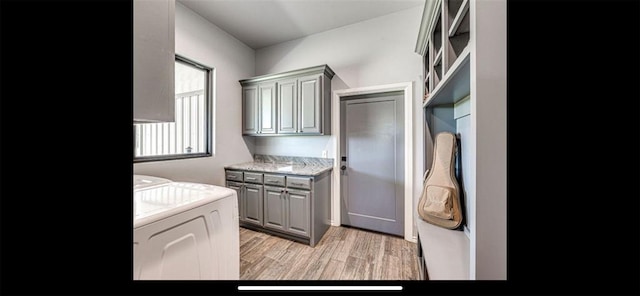 washroom with cabinet space, light wood-type flooring, and independent washer and dryer