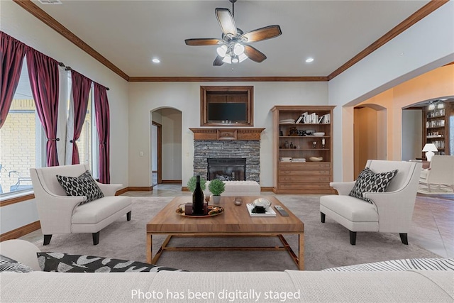 2612 SW 137th St, Oklahoma City, OK 73170 - living area with arched walkways, ceiling fan, ornamental molding, baseboards, and a stone fireplace