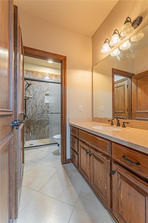 2612 SW 137th St, Oklahoma City, OK 73170 - full bathroom with vanity, a stall shower, tile patterned flooring, and toilet