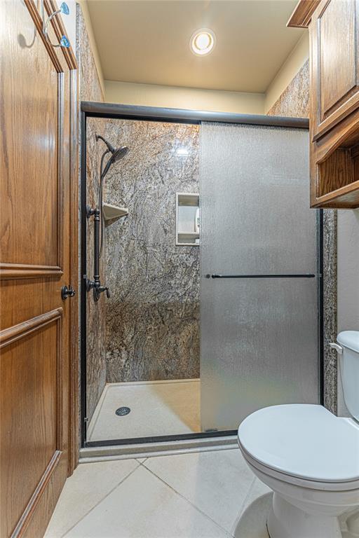 2612 SW 137th St, Oklahoma City, OK 73170 - bathroom with tile patterned flooring, a stall shower, and toilet