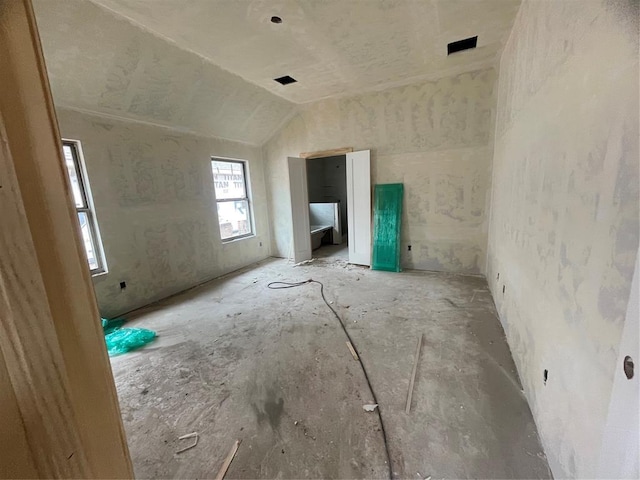 unfurnished living room featuring lofted ceiling