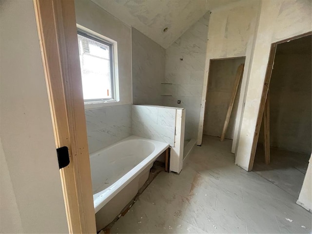 full bath featuring a bath and lofted ceiling
