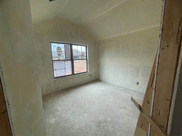 unfurnished room with vaulted ceiling