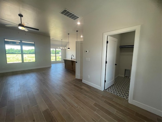 5012 Misty Wood Ln, Mustang, OK 73064 - unfurnished living room with dark wood-style floors, a ceiling fan, and a chandelier