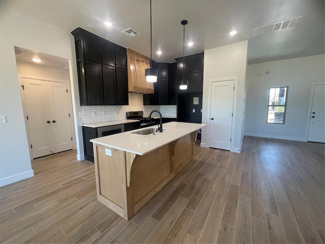 5012 Misty Wood Ln, Mustang, OK 73064 - kitchen featuring light wood-style floors, custom range hood, light countertops, and a center island with sink