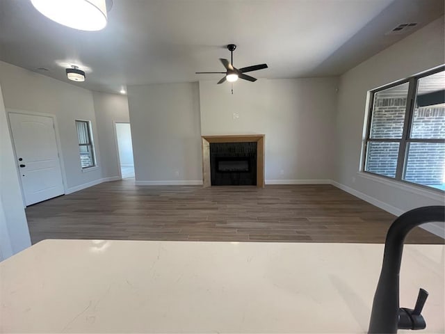 5012 Misty Wood Ln, Mustang, OK 73064 - unfurnished living room featuring ceiling fan, wood finished floors, and a tile fireplace