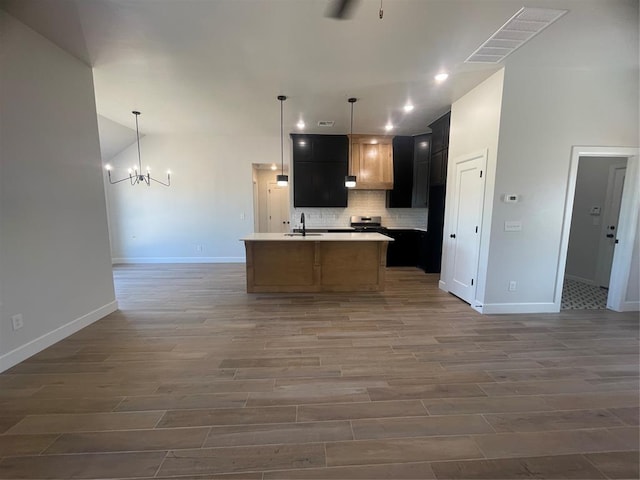 5012 Misty Wood Ln, Mustang, OK 73064 - kitchen with open floor plan, wood finished floors, a chandelier, tasteful backsplash, and light countertops