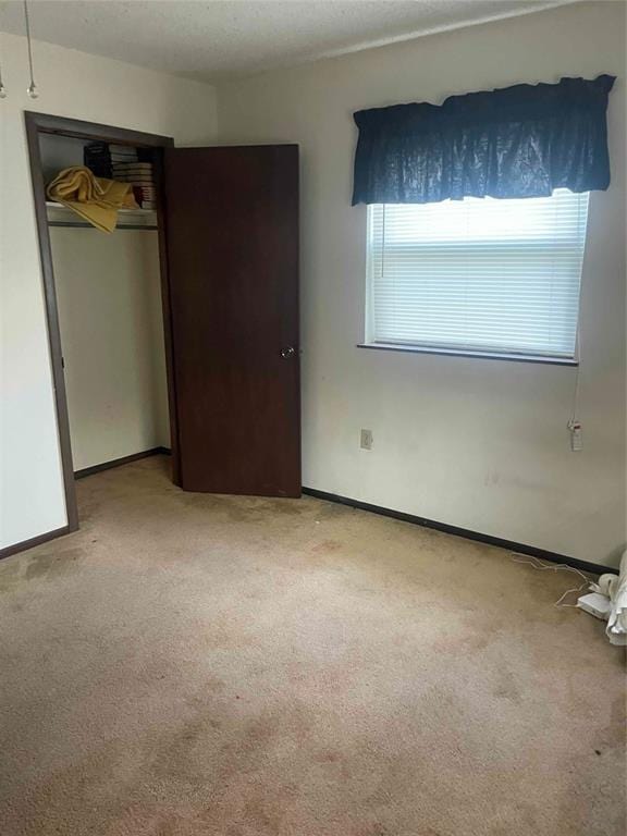 329131 E Lincoln St, Harrah, OK 73045 - unfurnished bedroom featuring light colored carpet, baseboards, and a closet