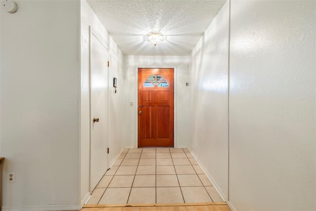 4113 Monica Dr, Del City, OK 73115 - doorway to outside featuring light tile patterned floors, a textured ceiling, and baseboards