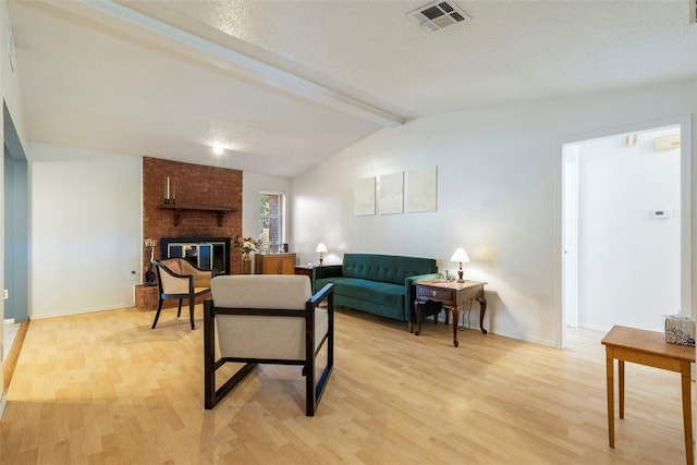 4113 Monica Dr, Del City, OK 73115 - living room with light wood-style flooring, a textured ceiling, baseboards, and a fireplace