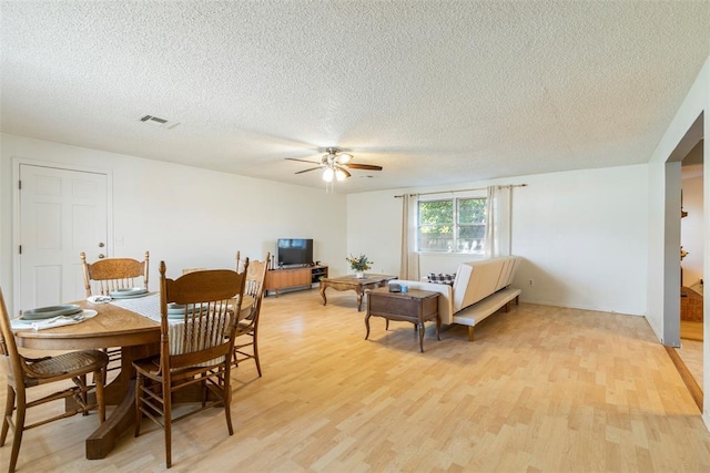 4113 Monica Dr, Del City, OK 73115 - dining area featuring a textured ceiling, light wood-type flooring, and a ceiling fan