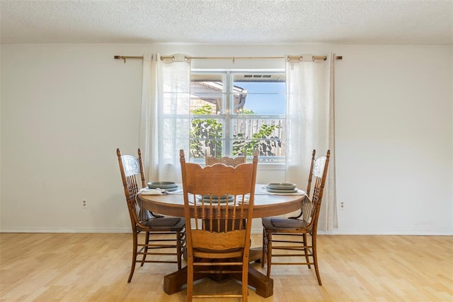 4113 Monica Dr, Del City, OK 73115 - dining space with light wood finished floors, a textured ceiling, and baseboards