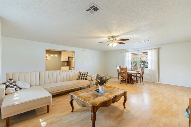 4113 Monica Dr, Del City, OK 73115 - living room with a textured ceiling, light wood-type flooring, and a ceiling fan