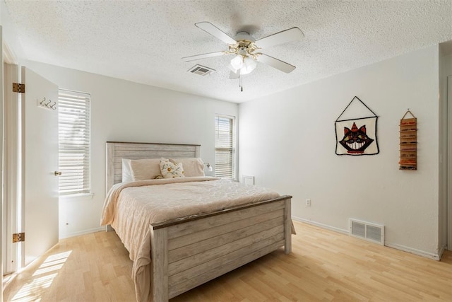4113 Monica Dr, Del City, OK 73115 - bedroom featuring a textured ceiling, light wood-style floors, baseboards, and ceiling fan