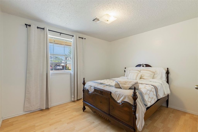 4113 Monica Dr, Del City, OK 73115 - bedroom featuring light wood-type flooring, a textured ceiling, and baseboards