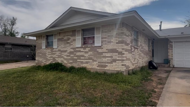 view of property exterior with a lawn, brick siding, a garage, and concrete driveway