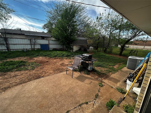 view of yard with a patio, fence, and central AC unit