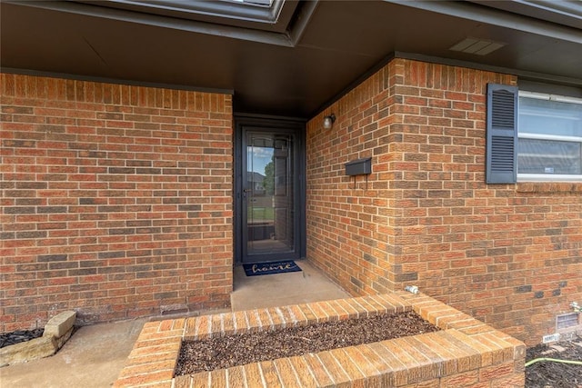 entrance to property featuring brick siding