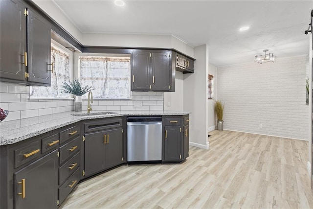 kitchen featuring light wood-style flooring, a sink, brick wall, stainless steel dishwasher, and backsplash
