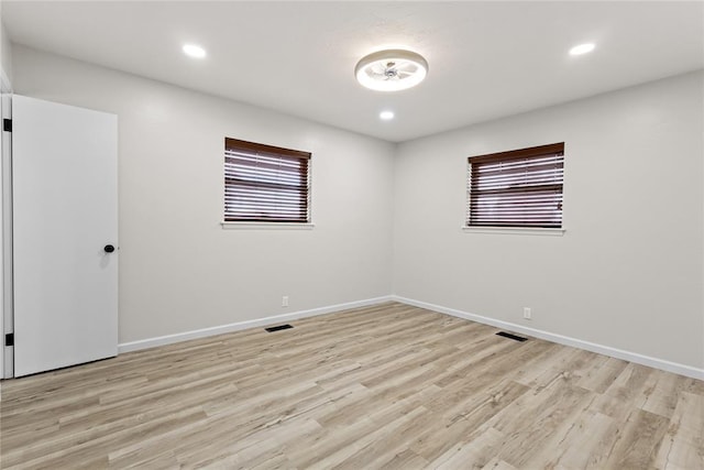 spare room with baseboards, recessed lighting, and light wood-type flooring