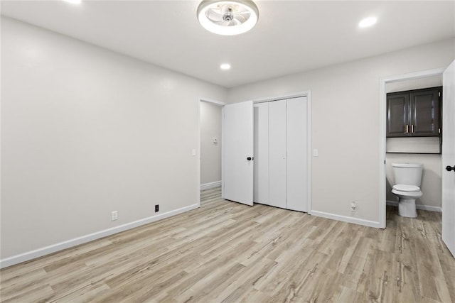 unfurnished bedroom featuring connected bathroom, baseboards, light wood-type flooring, and recessed lighting