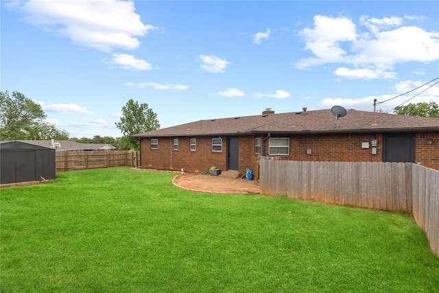 exterior space with brick siding, a yard, a shed, an outbuilding, and a fenced backyard