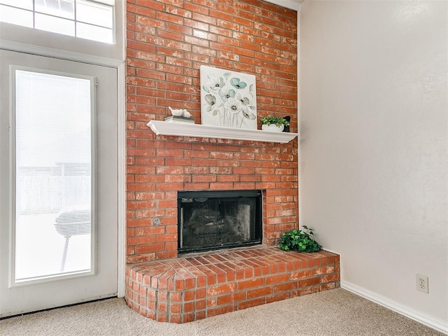 living room featuring carpet floors, plenty of natural light, a fireplace, and baseboards