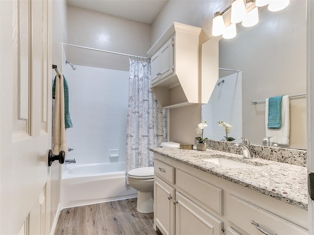 bathroom featuring wood finished floors, shower / tub combo, toilet, and vanity