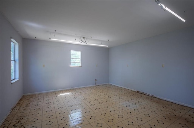 unfurnished room with baseboards