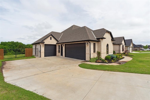 1111 Colonial Ave, Tuttle, OK 73089 - french country home featuring an attached garage, fence, a shingled roof, concrete driveway, and brick siding