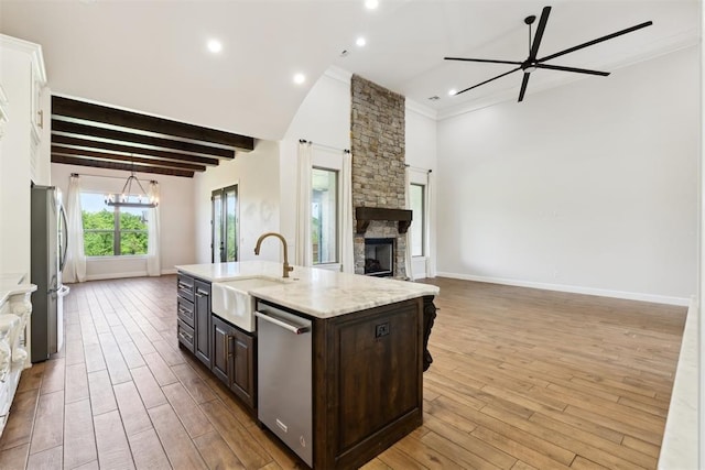 1111 Colonial Ave, Tuttle, OK 73089 - kitchen featuring a sink, light wood-style flooring, open floor plan, dark brown cabinets, and appliances with stainless steel finishes