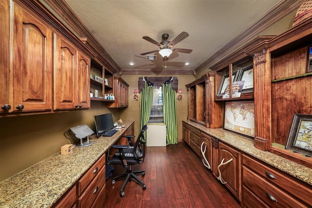 office with built in study area, visible vents, dark wood finished floors, ceiling fan, and crown molding