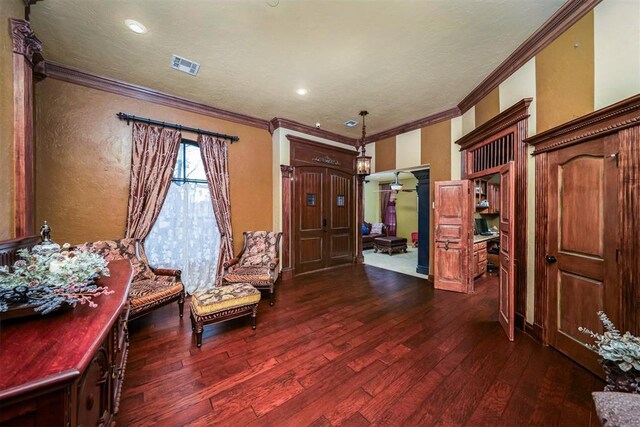 sitting room featuring ornamental molding, dark wood finished floors, ceiling fan, and visible vents