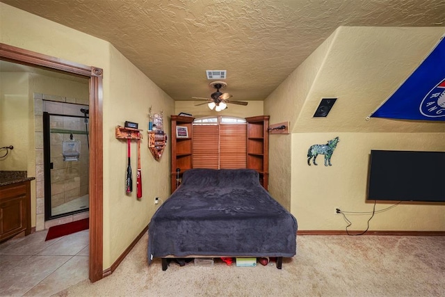 bedroom featuring light colored carpet, a textured ceiling, visible vents, and baseboards