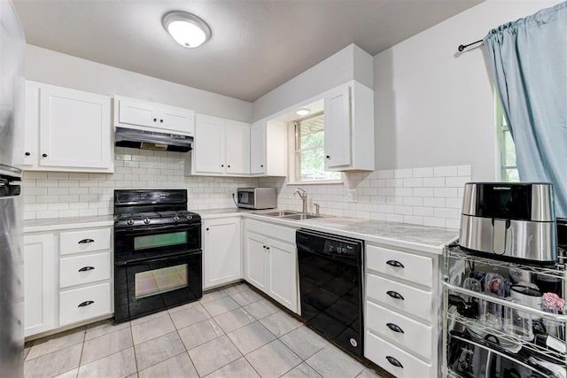 700 Redwood Dr, Noble, OK 73068 - kitchen with black appliances, under cabinet range hood, light countertops, decorative backsplash, and light tile patterned floors