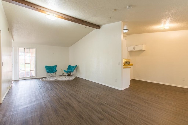 unfurnished room featuring a textured ceiling, baseboards, vaulted ceiling with beams, and dark wood-style floors