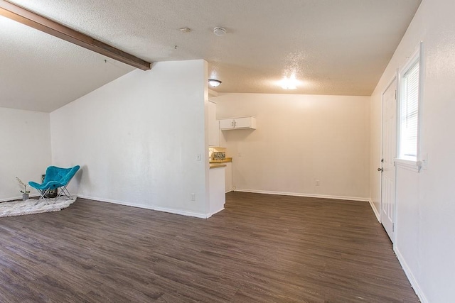 interior space featuring a textured ceiling, dark wood-type flooring, and baseboards