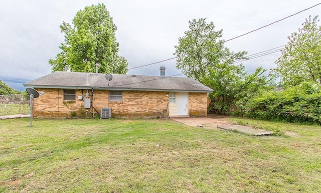 rear view of house featuring a yard, a patio area, cooling unit, and brick siding