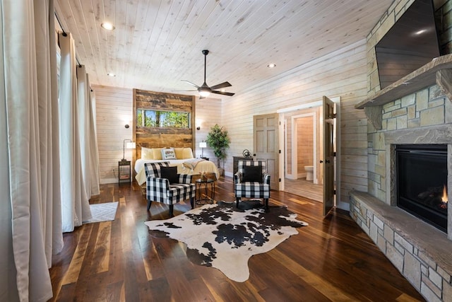 bedroom with wooden walls, a fireplace, hardwood / wood-style floors, and wood ceiling